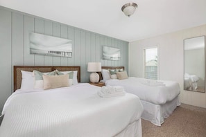 A hotel room with two beds, a large mirror, and a window with blinds. - Oceanfront, Pool, GolfCart, & Free EV Charger! (Ocean Isle Beach)