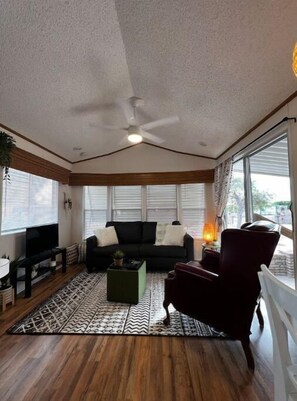 Relax in this inviting living room with a sofa, armchair, and patterned rug.