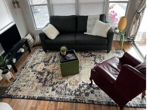 Relax in this stylish living room with a sofa, coffee table, and armchair, perfect for unwinding.