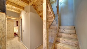 Una escala de fusta amb barana i zona d'aterratge amb una porta.
