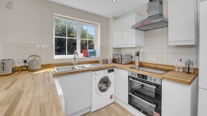 A modern kitchen with a built-in washer, oven, and a large window providing natural light.