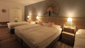 A bedroom with a large bed, two bedside tables with lamps, a mirror, and a wall-mounted fan. - Asia Dreieck Pension Zimmer (Lauterecken)