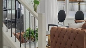 Un salon moderne avec un escalier, une grande fenêtre et une vue sur l’extérieur.