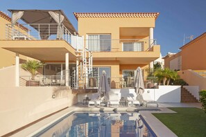 A two-story building with a swimming pool, outdoor seating, and a staircase. - My Island Escape (Santiago del Teide)