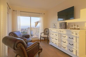 A living room with a large window, a leather armchair, a white cabinet, and a mounted television. - My Island Escape (Santiago del Teide)