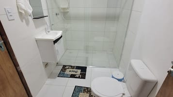 Casa de banho com chuveiro, sanita, lavatório e barra de toalhas.