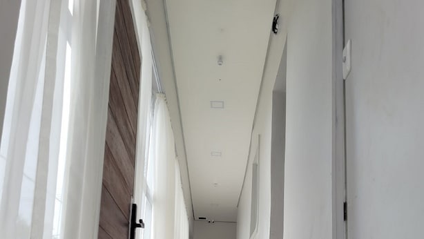 A narrow hallway with white walls and a wooden door on the left. - Hotel Manaus - Dom Pedro (Manaus)