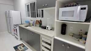 A modern kitchen with grey cabinets, a white countertop, a microwave, a coffee maker, and a blender. - Hotel Manaus - Dom Pedro (Manaus)