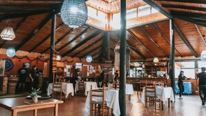 Ein rustikales Restaurant mit Holzbalken und gedeckten Tischen.