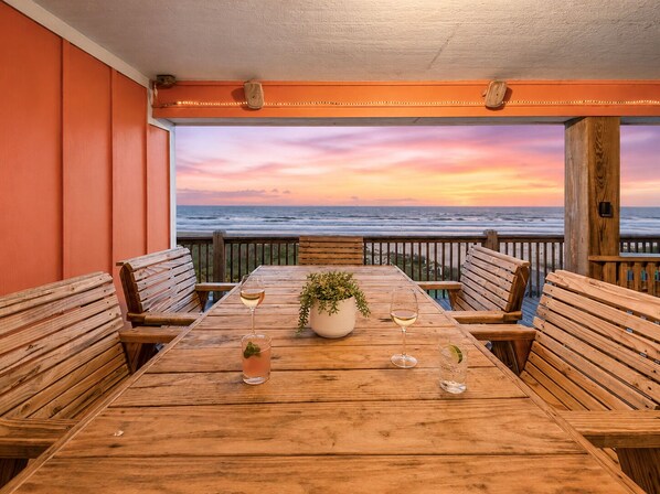 A wooden table with four benches, a potted plant, and three glasses of beverages.