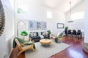 A modern living room with a sofa, chairs, a coffee table, and artwork on the walls.
