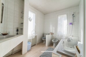 Bathtub, hair dryer, towels, toilet paper