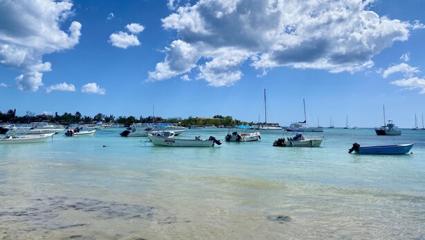 Ein Yachthafen mit verschiedenen vertäuten Booten, blauem Himmel und ruhiger See.