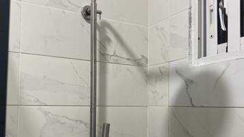 A shower with a handheld showerhead and a handheld hose.