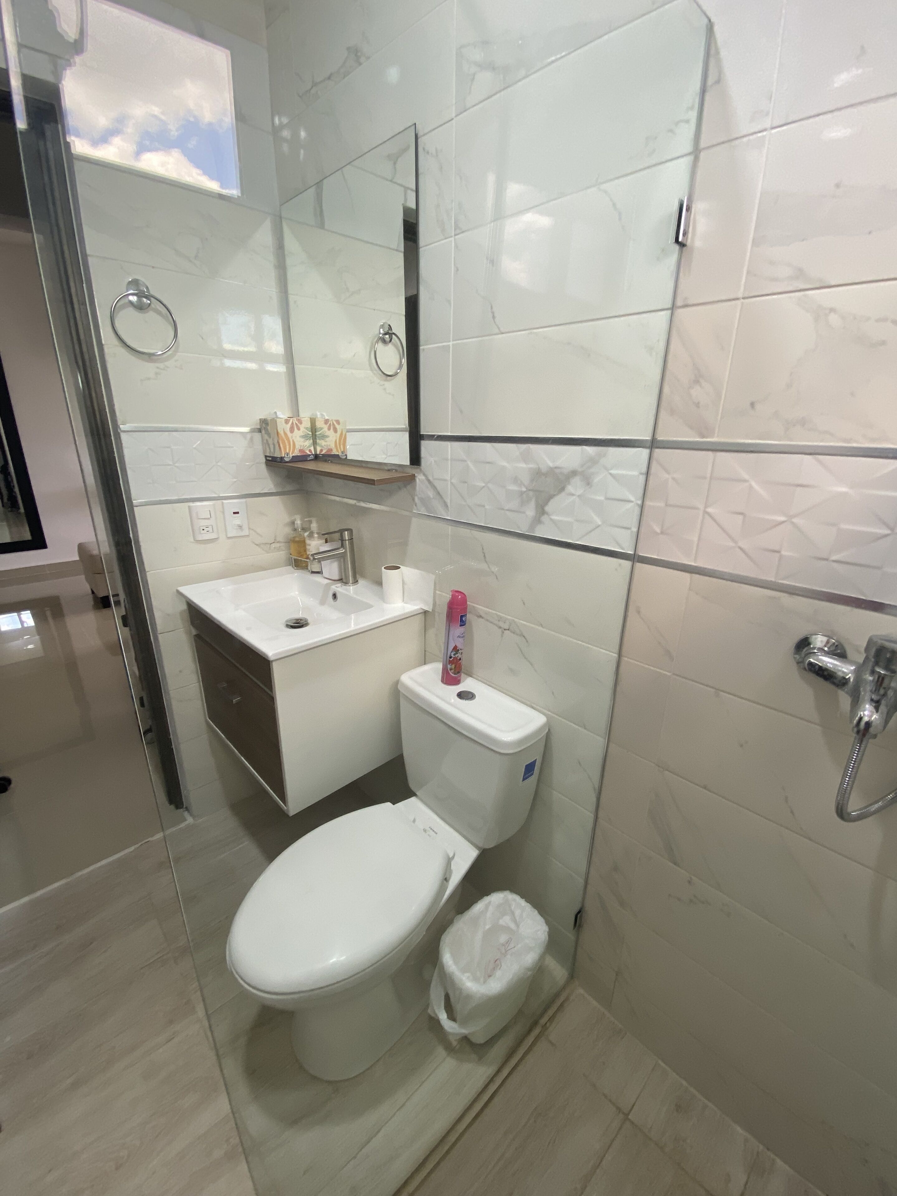 A modern bathroom with a toilet, sink, and shower.