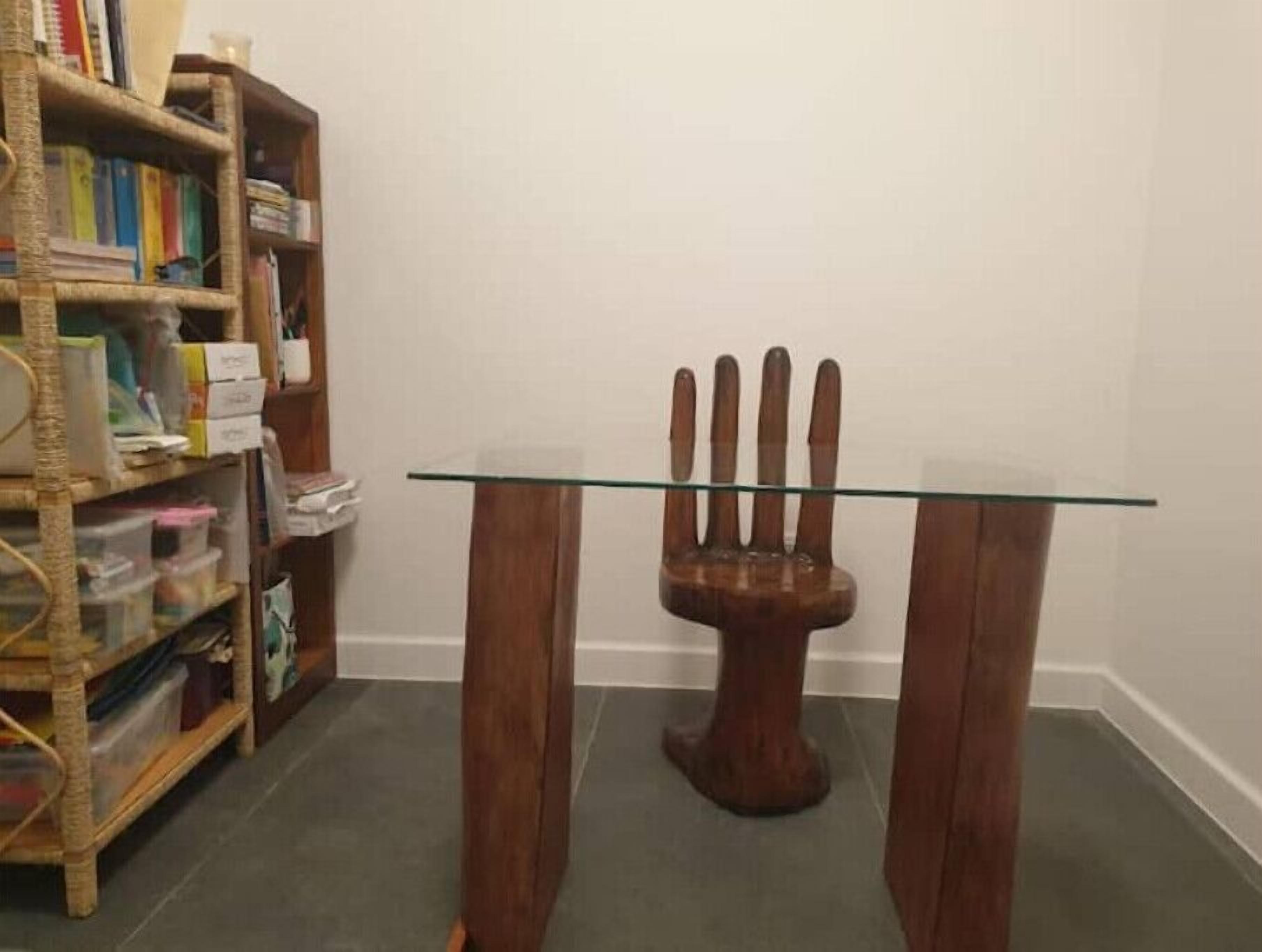 Una habitación con una mesa de cristal y una escultura de madera.