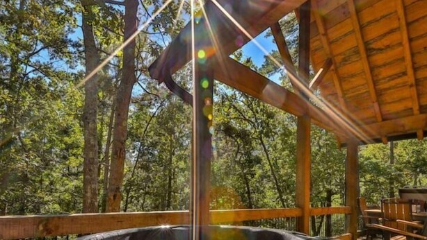 A hot tub in a wooden gazebo surrounded by trees. - Chalet Bellaboo
Lic.#004390 (Ellijay)