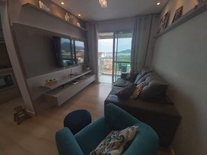 Apartamento luxo, acesso à piscina, vista para o mar | Área de estar | TV 32 polegadas com canais digitais, pebolim, mesa de pingue-pongue