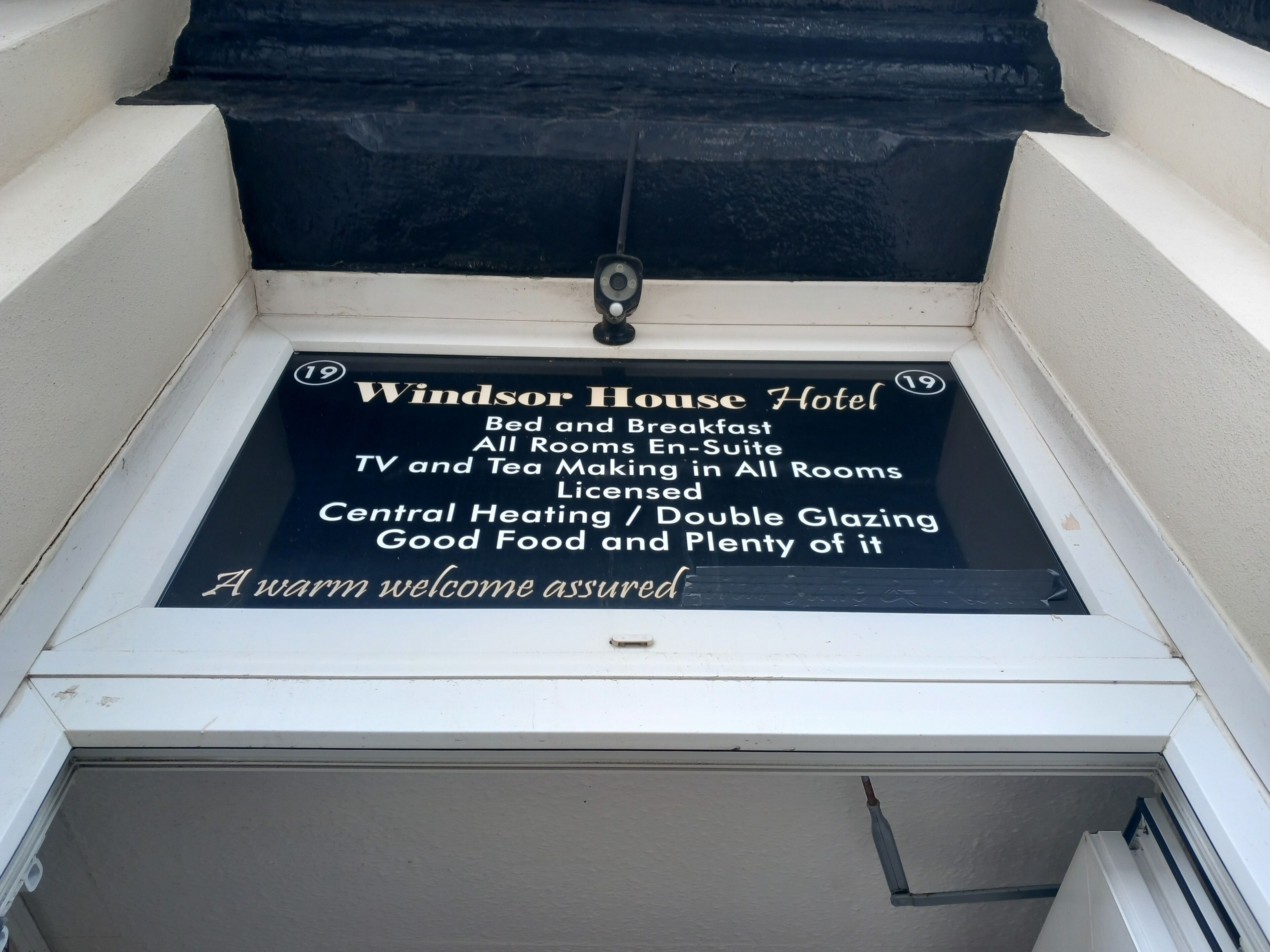 A hotel signboard with amenities including bed and breakfast, en-suite TV, tea making, licensed central heating, double glazing, and good food.