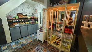 A small shop with shelves stocked with snacks and a display case with various items. - Windsor House Hotel  (Blackpool)