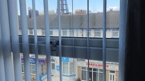 A view through window bars of a building with a sign for 'Central Heating' and a tower in the background. - Windsor House Hotel  (Blackpool)
