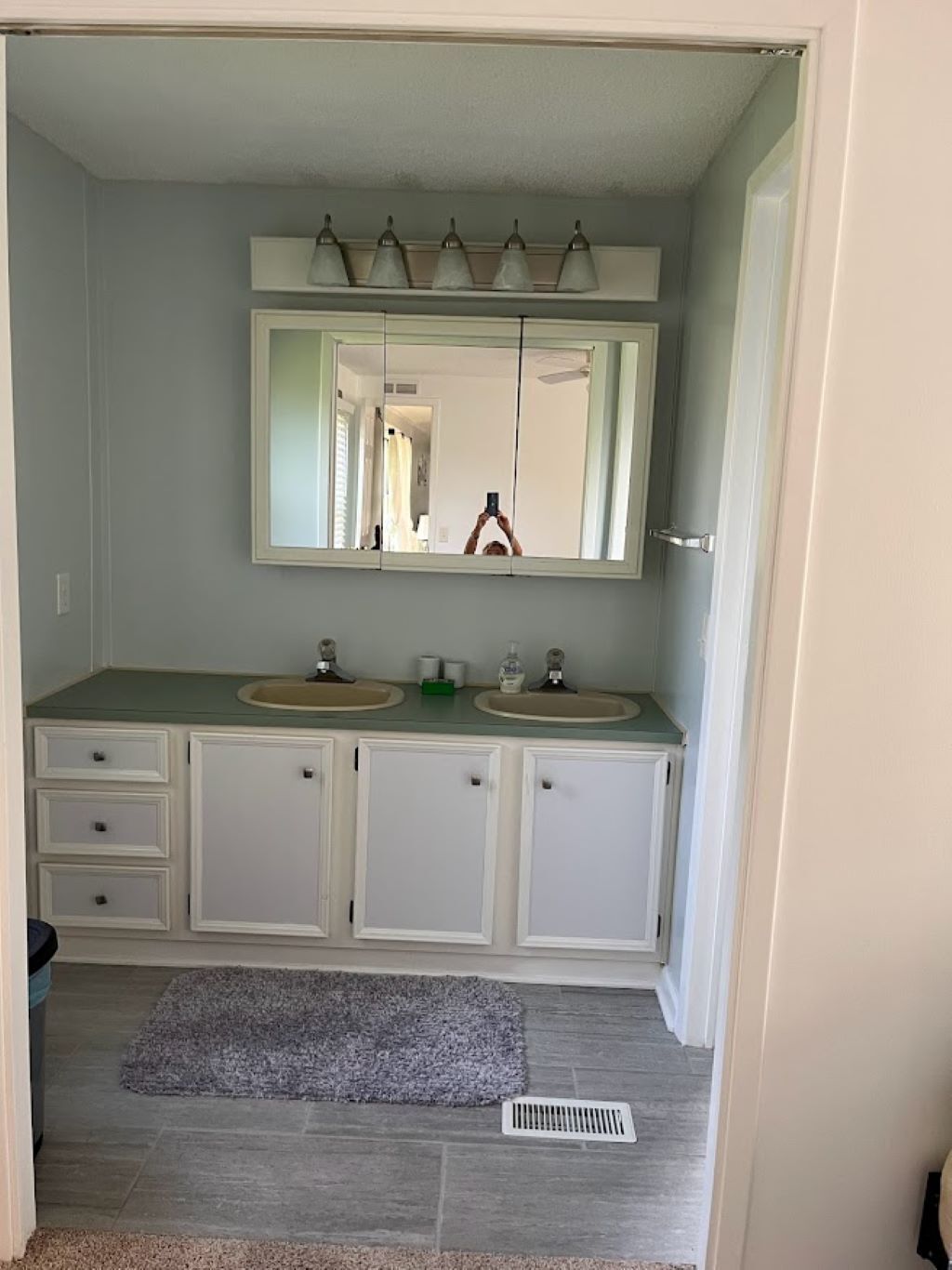 Une salle de bain avec deux lavabos, un miroir et un porte-serviettes.