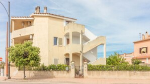 A multi-story building with a unique architectural design, featuring balconies and a staircase. - GuestHost - Cozy apartment of 65 sqm, able to accommodate up to 3 people, located on the second floor of a building without elevator. The property is equipped with every comfort, including air conditioning and a large terrace overlooking the city of Olbi (Olbia)