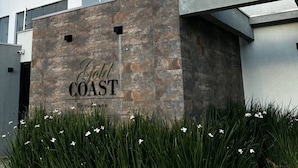 A modern building with a sign that reads "Gold Coast Residences." - Ap Gold Coast Vista Mar - Piçarras - SC (Picarras)