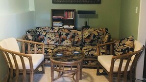A living room with a sofa, two armchairs, a coffee table, and a bookshelf. - Gypsywind Home (Edmonton)