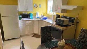 A compact kitchen with white cabinets, a microwave, and a sink. - Gypsywind Home (Edmonton)