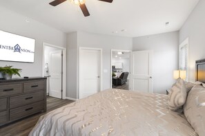 A bedroom with a bed, dresser, ceiling fan, and a TV on the wall. - Private Hot Tub, Golf Course Onsite, Free Tickets, Gated Community, Close to Silver Dollar City (Branson West)