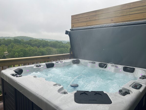 A hot tub with a wooden deck and a view of a forested landscape. - Private Hot Tub, Golf Course Onsite, Free Tickets, Gated Community, Close to Silver Dollar City (Branson West)