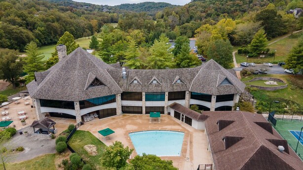 A large, multi-story building with a central courtyard, a swimming pool, and a tennis court. - Stonebridge Resort Condo w Onsite Golf_Private Hot Tub_Outdoor Pool_Free Tickets (Branson West)