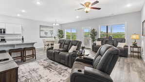 A spacious living room with a large sectional sofa, a dining area, and a kitchen. - Stonebridge Resort Condo w Onsite Golf_Private Hot Tub_Outdoor Pool_Free Tickets (Branson West)