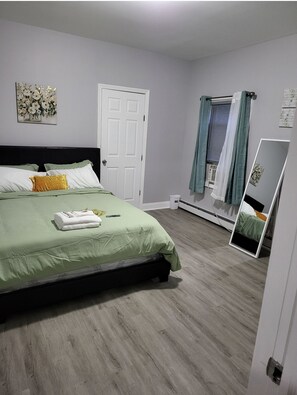 Cozy retreat with a neatly made bed and a small mirror.