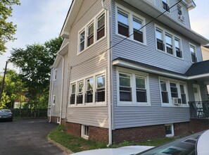 Stunning two-story home with a classic facade, featuring a front porch and a driveway.