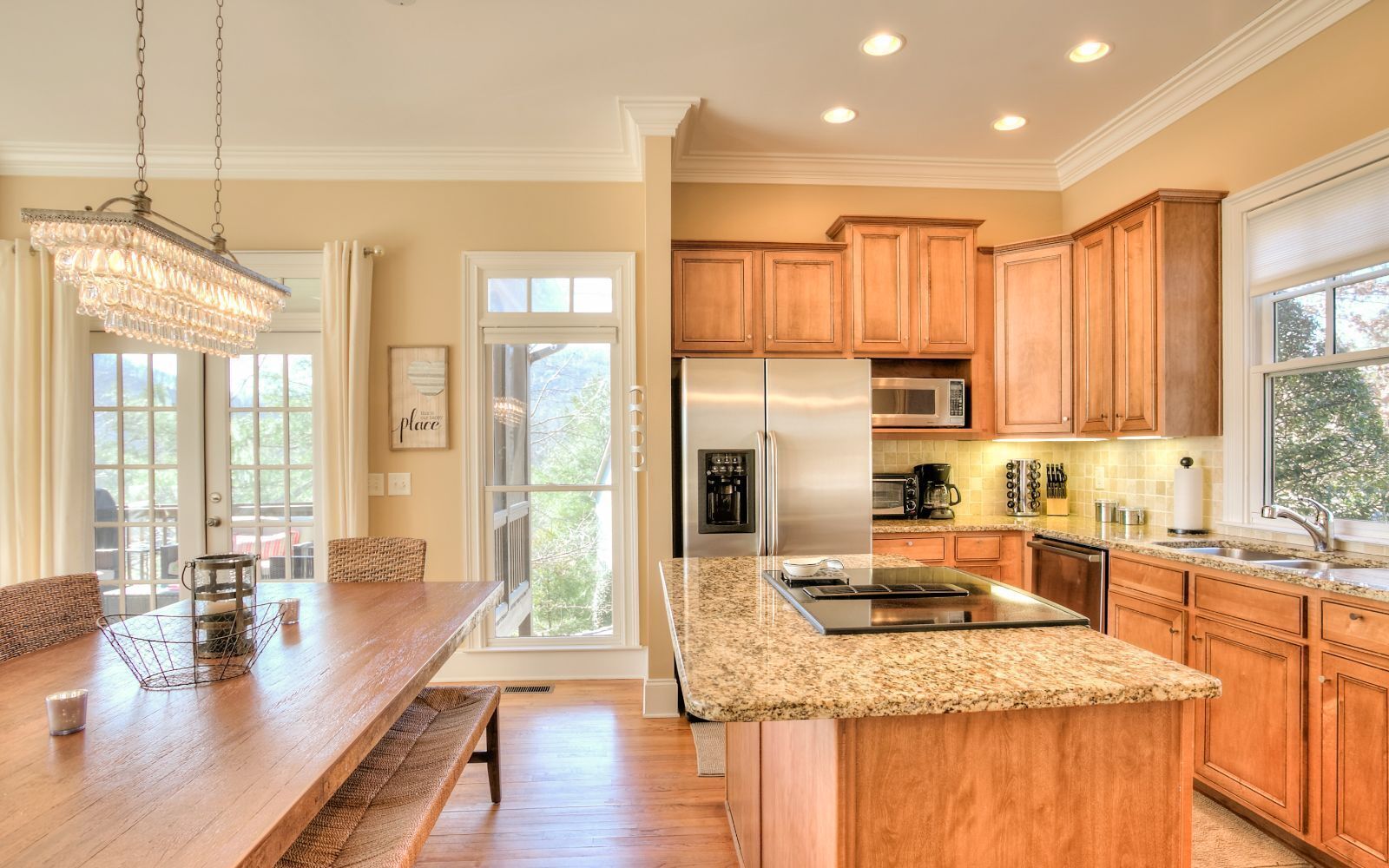 A spacious kitchen with wooden cabinets, granite countertops, stainless steel appliances, and a large island.