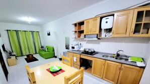 Une cuisine compacte avec des meubles en bois, un four à micro-ondes encastré et un évier.