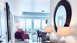 Una hall d'hotel moderna con un'ampia area salotto, un grande specchio e interni ben illuminati.