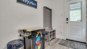 Een receptiebalie met twee krukken, een deur en een bord aan de muur.