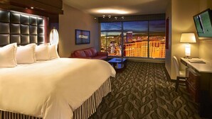 A hotel room with a large bed, a desk, a TV, and a view of a cityscape. - Stay in Style at Elara Hilton's 2BR Suite During the Las Vegas Formula 1 Race. (Las Vegas)