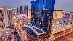 A cityscape with modern high-rise buildings, a curved road, and a parking area. - Stay in Style at Elara Hilton's 2BR Suite During the Las Vegas Formula 1 Race. (Las Vegas)
