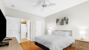 A bedroom with a bed, bedside table, lamp, and ceiling fan. - North Myrtle Beach Condo (North Myrtle Beach)