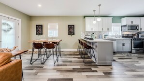 Una cucina moderna con isola centrale, mobili bianchi ed elettrodomestici in acciaio inossidabile.
