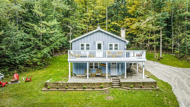 A two-story cabin with a balcony, surrounded by a forest. - Modern Chalet w/ Serene Views and Jacuzzi Hot Tub- 15 Minutes to Okemo Mountain (Chester)