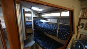 A compact, single-berth cabin with a bunk bed, a small seating area, and a window providing natural light. - Beautiful Yacht on Catskill Creek (Catskill)