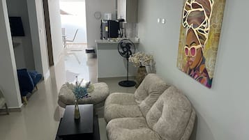 Ein modernes Wohnzimmer mit einer Couch, einem Couchtisch und einem Gemälde an der Wand.