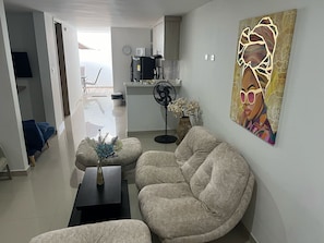Un salon moderne avec un canapé, une table basse et un tableau accroché au mur.