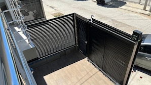 A gated entrance to a building with a tiled floor and a metal fence.