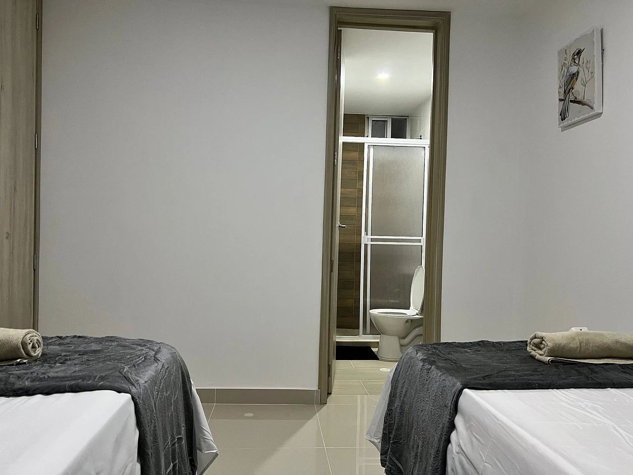 Una habitación con dos camas, ducha y baño.